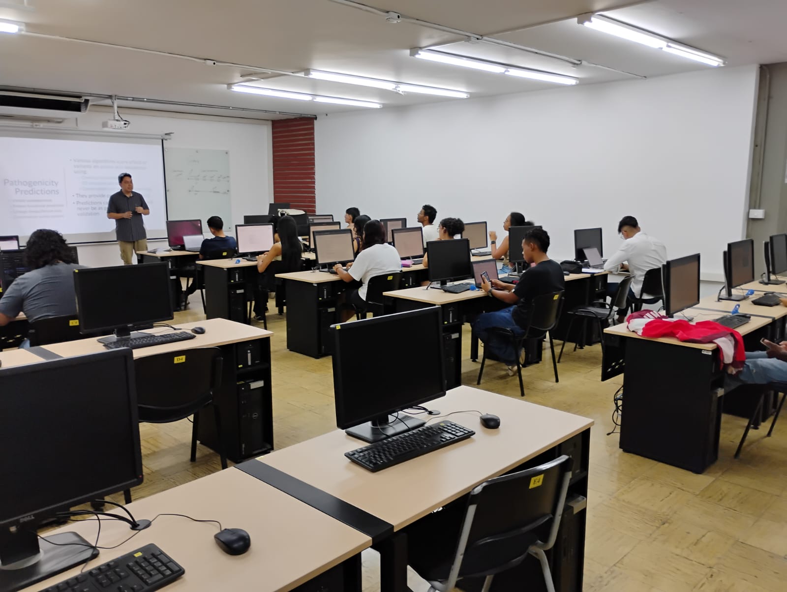 Mesas con computadores de escritorio en una sala de sistemas
